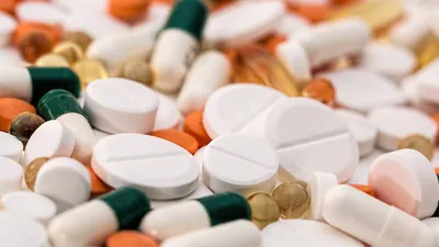Různé druhy léků – tablety, kapsle a pilulky rozložené na bílém podkladu